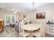 Open-concept dining area with elegant chandelier and seating for six at 6734 Blue Heron Blvd. # 104, Myrtle Beach, SC 29588
