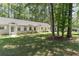 Exterior view of home with light colored siding, well manicured lawn, and tree lined street at 6734 Blue Heron Blvd. # 104, Myrtle Beach, SC 29588