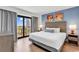 Bright bedroom featuring a balcony with ocean views, wood flooring, and modern decor at 7100 N Ocean Blvd. # 317, Myrtle Beach, SC 29572