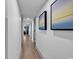 Long hallway with wood floors and art decorations on the white walls at 7100 N Ocean Blvd. # 317, Myrtle Beach, SC 29572