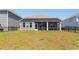 Exterior of home showing backyard, screened porch, landscaped lawn, and black metal fence at 8077 Fort Hill Way, Myrtle Beach, SC 29579