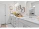 Bright bathroom featuring a double vanity with white countertops and cabinets and decorative wall art at 8077 Fort Hill Way, Myrtle Beach, SC 29579