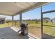 Screened porch with grill, concrete patio, and view of the backyard and lake at 8077 Fort Hill Way, Myrtle Beach, SC 29579