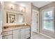 Well-lit bathroom with double vanity, framed mirror, granite countertops, and natural light from a window at 8209 Timber Ridge Rd., Conway, SC 29526