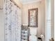 Cozy bathroom with patterned shower curtain, toilet with storage, and framed wall art by window at 8209 Timber Ridge Rd., Conway, SC 29526