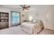 A bright bedroom with a decorative ceiling fan, large window and a comfortable bed with floral patterns at 8209 Timber Ridge Rd., Conway, SC 29526