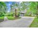 Long driveway leading to a house with a gray garage and palm trees at 8209 Timber Ridge Rd., Conway, SC 29526