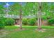 Front exterior of a brick home with trees and manicured bushes at 8209 Timber Ridge Rd., Conway, SC 29526