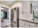 A modern kitchen showcases stainless steel refrigerator, white cabinets, and easy access to other rooms at 8209 Timber Ridge Rd., Conway, SC 29526