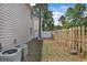 Fenced backyard with lawn, trees, and exterior AC units at 829 9Th Ave. S, North Myrtle Beach, SC 29582
