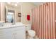 This bathroom features a single vanity, toilet, and a shower/tub with red and white striped curtain at 8796 Cloister Dr. # B, Surfside Beach, SC 29575