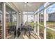 Cozy screened porch with a table and chairs overlooking the community green space at 8796 Cloister Dr. # B, Surfside Beach, SC 29575