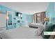 Inviting bedroom with balcony, two beds, bright teal walls, and light wood flooring under ambient lighting at 9550 Shore Dr. # 226, Myrtle Beach, SC 29572