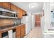 Efficient kitchen with stainless steel microwave, wood cabinets, and tile flooring with a clear hallway view at 9550 Shore Dr. # 226, Myrtle Beach, SC 29572