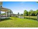 Fenced backyard overlooking a pond with mature trees and outdoor kitchen at 985 Shipmaster Ave., Myrtle Beach, SC 29579
