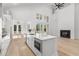 Modern white kitchen features an island, stainless appliances, and a fireplace at 985 Shipmaster Ave., Myrtle Beach, SC 29579