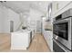Modern kitchen with stainless steel appliances, an island with seating, and views into the living area and staircase at 985 Shipmaster Ave., Myrtle Beach, SC 29579