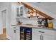 Stylish bar area with a wine fridge, marble countertop, custom cabinets, and a display shelf for liquor at 1004 Whooping Crane Dr., Conway, SC 29526