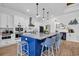 Modern kitchen with a large blue island, marble countertops, white cabinets, and pendant lighting at 1004 Whooping Crane Dr., Conway, SC 29526