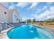 Backyard pool with a stone-paved patio and surrounding greenery at 1004 Whooping Crane Dr., Conway, SC 29526