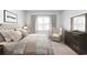 Bright bedroom featuring a patterned bedspread, accent chair, and dresser with elegant mirror at 1005 Laconic Dr., Myrtle Beach, SC 29588
