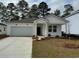 Charming single-story home featuring a spacious garage, welcoming front porch and manicured lawn at 1005 Laconic Dr., Myrtle Beach, SC 29588