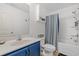 Well-lit bathroom featuring a blue vanity, toilet with storage, and shower-tub combination at 101 Winding Path Dr., Loris, SC 29569