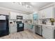 Well-lit kitchen featuring white cabinets, black appliances, and a subway tile backsplash at 101 Winding Path Dr., Loris, SC 29569