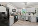 Well-lit kitchen featuring black appliances, white cabinets, and light countertops at 101 Winding Path Dr., Loris, SC 29569