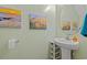 Charming powder room with a pedestal sink and coastal artwork at 101 Winding Path Dr., Loris, SC 29569