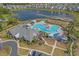Aerial view of a resort-style community pool, clubhouse, and picturesque lake with fountain features at 1011 Maxwell Dr., Little River, SC 29566
