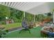 Inviting covered patio featuring an egg chair, plush seating, and playset in the landscaped backyard at 1011 Maxwell Dr., Little River, SC 29566