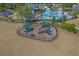 Aerial view of the community playground with multiple slides and play areas, surrounded by green space and fencing at 1011 Maxwell Dr., Little River, SC 29566