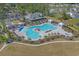 Aerial view of the community pool with plenty of seating and sun umbrellas next to the clubhouse and parking at 1011 Maxwell Dr., Little River, SC 29566