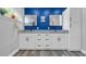 A modern bathroom features a dual vanity with granite counters and a blue accent wall at 1014 Academy Dr., Conway, SC 29526
