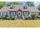 Charming brick home featuring dormer windows, white trim, a welcoming front porch and landscaped yard at 1014 Academy Dr., Conway, SC 29526