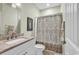 Bathroom featuring shower and tub combination with beige patterned curtain and marble vanity top at 1033 Tuckers Rd., Pawleys Island, SC 29585