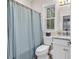 Bright bathroom featuring a shower with blue and white striped curtains and a white vanity with a marble countertop at 1033 Tuckers Rd., Pawleys Island, SC 29585