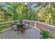 Outdoor deck area features a table with four chairs overlooking the lush backyard and trees at 1033 Tuckers Rd., Pawleys Island, SC 29585