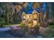 Charming two-story home with a well-manicured lawn and lush landscaping at twilight at 1033 Tuckers Rd., Pawleys Island, SC 29585