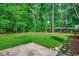 Expansive lush green backyard bordered by mature trees, as seen from the concrete patio at 107 Azalea Dr., Conway, SC 29526