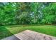 A view of the expansive grassy backyard bordered by mature trees from a stone patio at 107 Azalea Dr., Conway, SC 29526