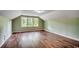 Spacious bedroom with wood-look floors and multiple windows allowing for plenty of natural light at 107 Azalea Dr., Conway, SC 29526