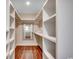 Walk-in closet featuring hardwood floors, custom shelving, and lots of storage at 107 Azalea Dr., Conway, SC 29526