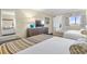 Comfortable bedroom featuring two beds, dresser with TV, and view of the outside at 1105 S Ocean Blvd. # 1024, Myrtle Beach, SC 29572