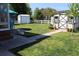 Lush backyard featuring shed, white fence, and a dog relaxing on the deck at 1145 Forest Dr., North Myrtle Beach, SC 29582