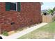 Side exterior view of brick home with a fenced yard and a flower bed along the walkway at 1145 Forest Dr., North Myrtle Beach, SC 29582