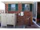 Rear exterior view of brick house with green shutters, outdoor shower, and wooden railing at 1145 Forest Dr., North Myrtle Beach, SC 29582