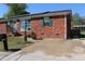 Charming brick home with well-maintained lawn, a small garden, and solar panels on the roof at 1145 Forest Dr., North Myrtle Beach, SC 29582