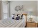 Bedroom with a queen bed, seashell pillows, wooden headboard, and a decorative fish at 126 N Waccamaw Dr. # 101, Garden City Beach, SC 29576